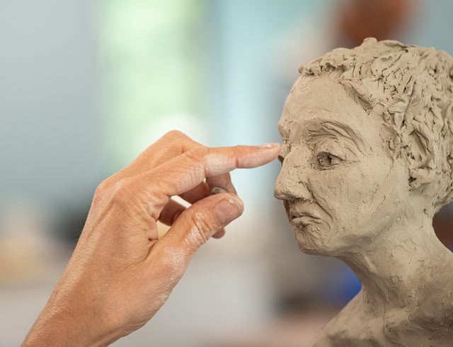 making a clay figure in sculpture class