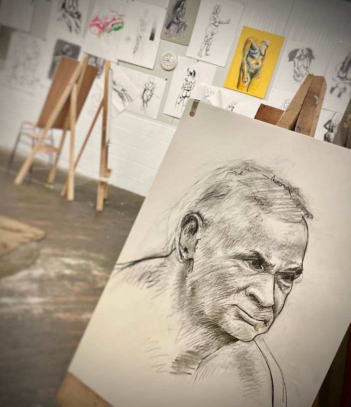 Figure drawing in black and white on grey paper.